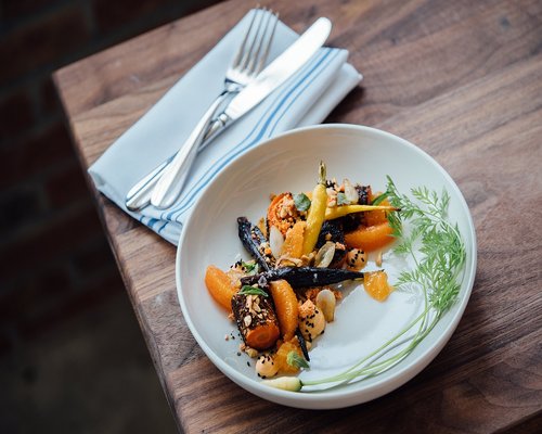 A balanced plate of local food with vegetables and rice on a wooden table